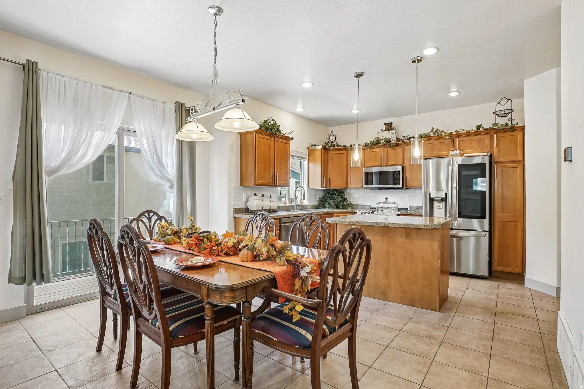 Kitchen featuring wood-finish cabinetry, stainless steel appliances, and a central island with countertop seating