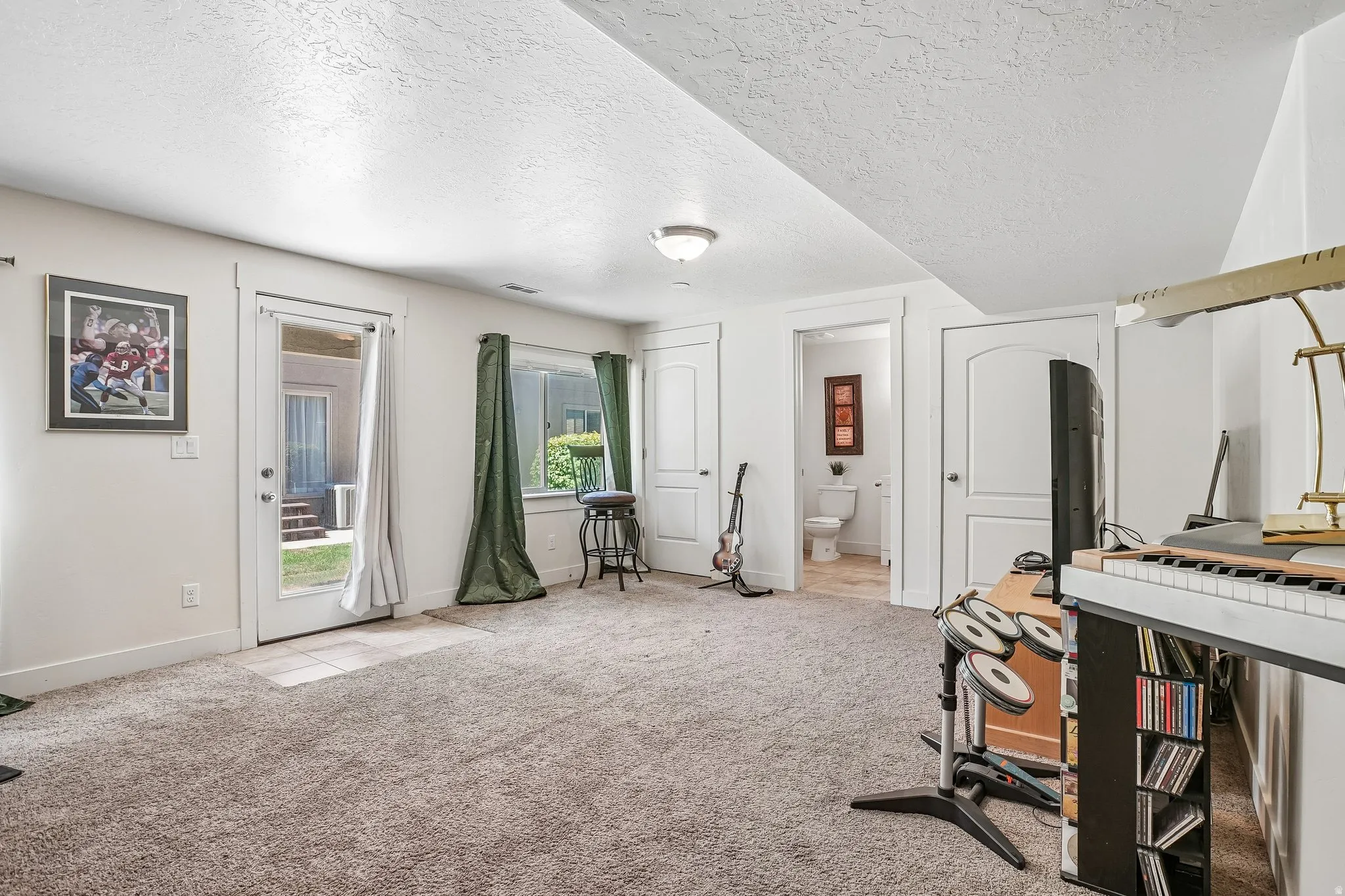 Carpeted flooring, recessed lighting, white trim, interior doors with arched panels, and a glass-paneled exterior door