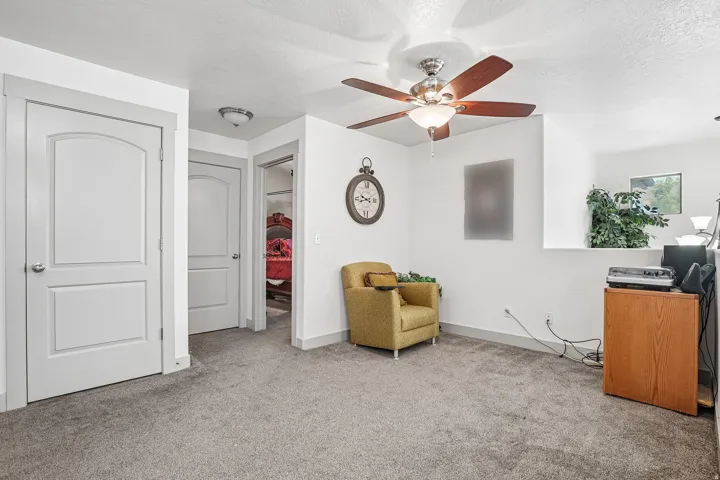 Ceiling fan with light fixture, carpeted flooring, white walls, and white interior doors