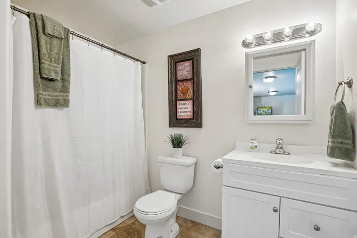 White vanity with an integrated sink, brushed nickel faucet, and a wall-mounted medicine cabinet