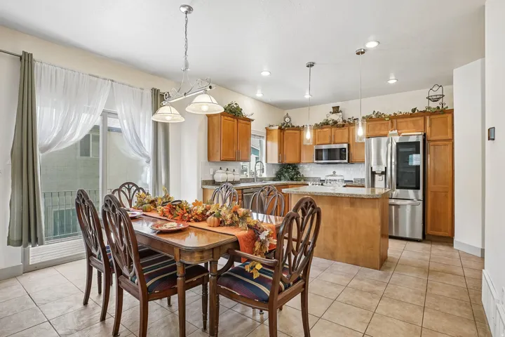 Kitchen featuring wood-finish cabinetry, stainless steel appliances, and a central island with countertop seating