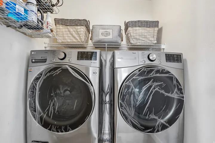 Laundry area featuring a side-by-side washer and dryer, along with built-in wire shelving