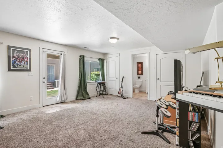 Carpeted flooring, recessed lighting, white trim, interior doors with arched panels, and a glass-paneled exterior door