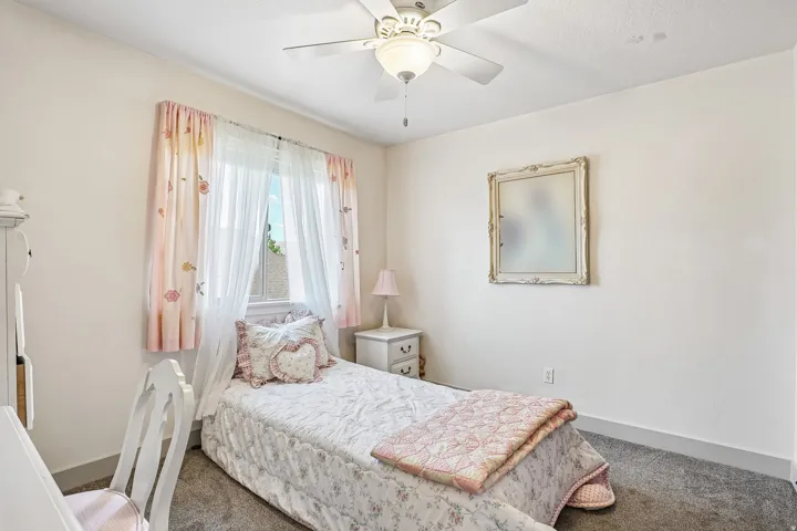 Wall-to-wall carpeting and a ceiling fan with integrated lighting
