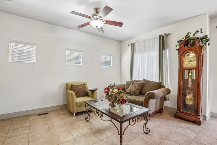 Recessed lighting, wood-finish ceiling fan, tile flooring, and multiple windows with blinds