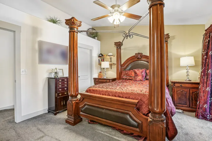 Wall-to-wall carpeting and a ceiling fan with integrated lighting