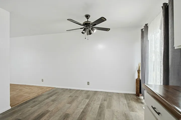 Recessed lighting, wood-finish flooring, and a ceiling fan with integrated lighting