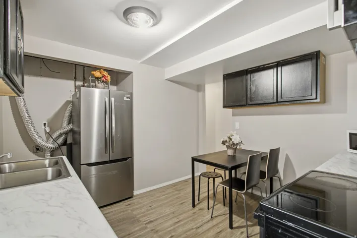 Wood-finish flooring with white countertops and a double basin sink