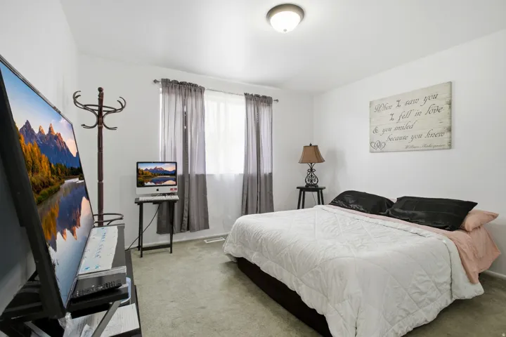 Recessed ceiling light, wall-to-wall carpeting, and a window with privacy curtains