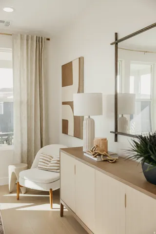 Recessed lighting, light wood-finish flooring, full-length window, and a built-in sideboard with integrated handles