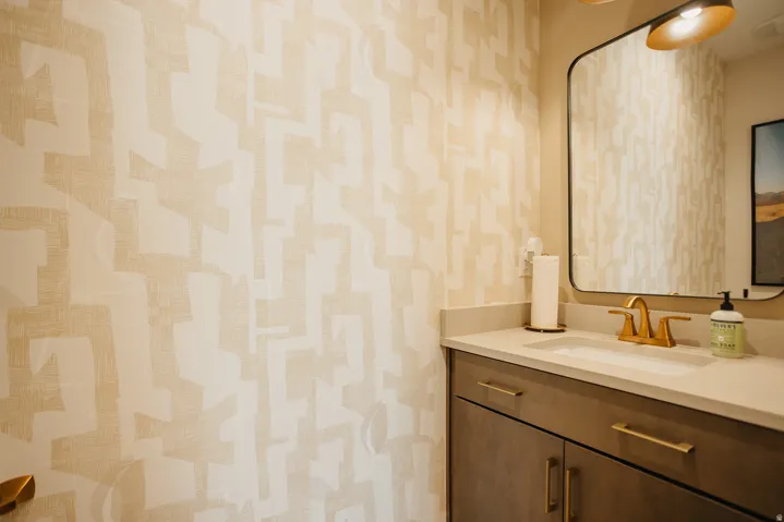 Vanity with a single basin sink, gold-finish faucet, and coordinating hardware