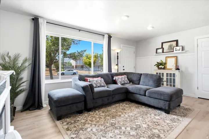 Expansive window, recessed lighting, wood-finish flooring, white paneled doors, and wainscoting