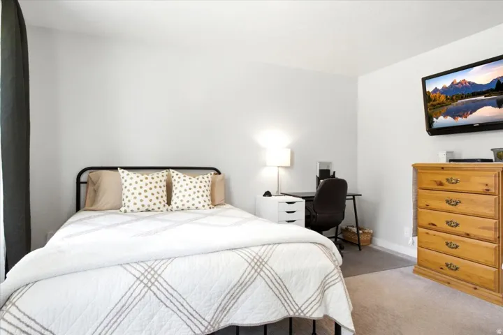 Neutral wall paint, wall-to-wall carpeting, and a window with dark drapery