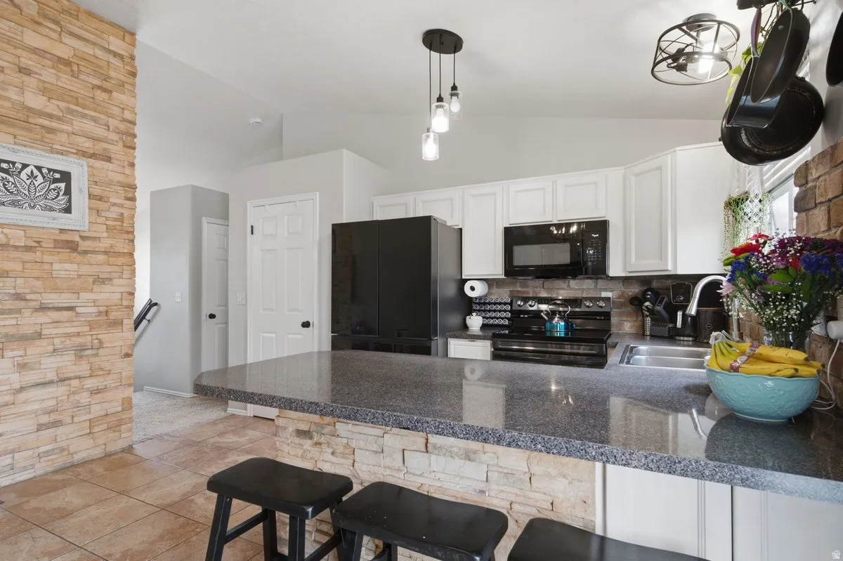 Modern kitchen featuring white cabinetry, stainless steel appliances, and a spacious island with seating for two