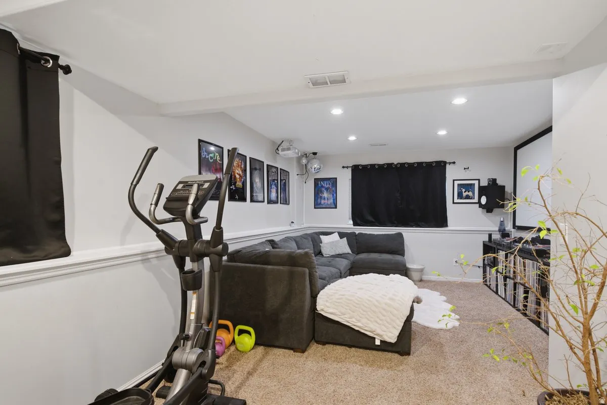 Recessed ceiling lighting, light gray wall paint, carpeted flooring, white trim, and a built-in entertainment area