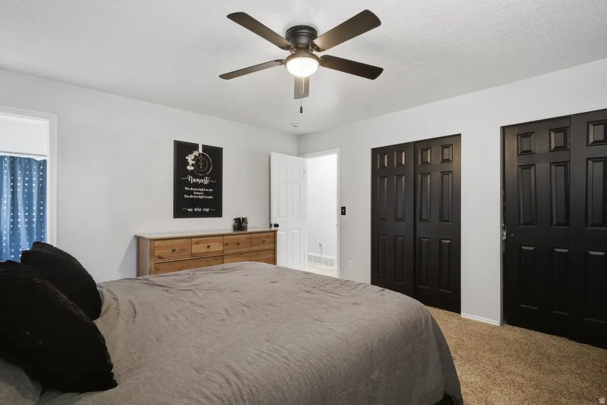 Ceiling fan with integrated lighting, wall-to-wall carpeting, and panel doors