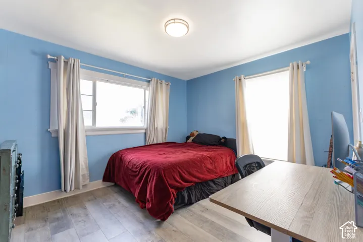 Recessed ceiling lighting, two windows with white trim, and wood-finish flooring