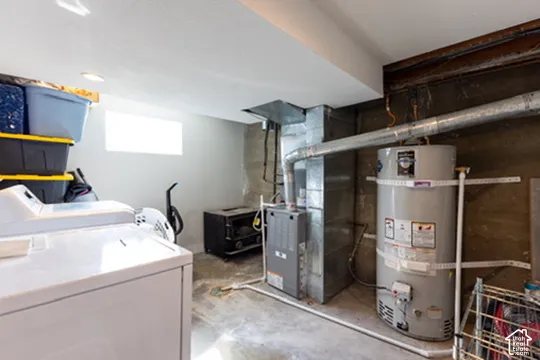 Utility and laundry area featuring a water heater, furnace, and window