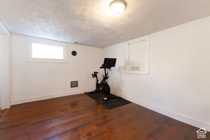 Wood-finish flooring with white baseboards, recessed window, and flush-mount ceiling light