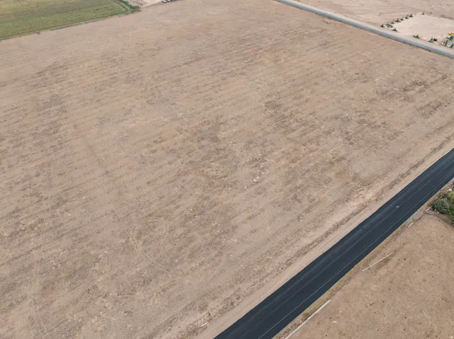 Expansive undeveloped parcel featuring a cleared, level terrain and established road frontage