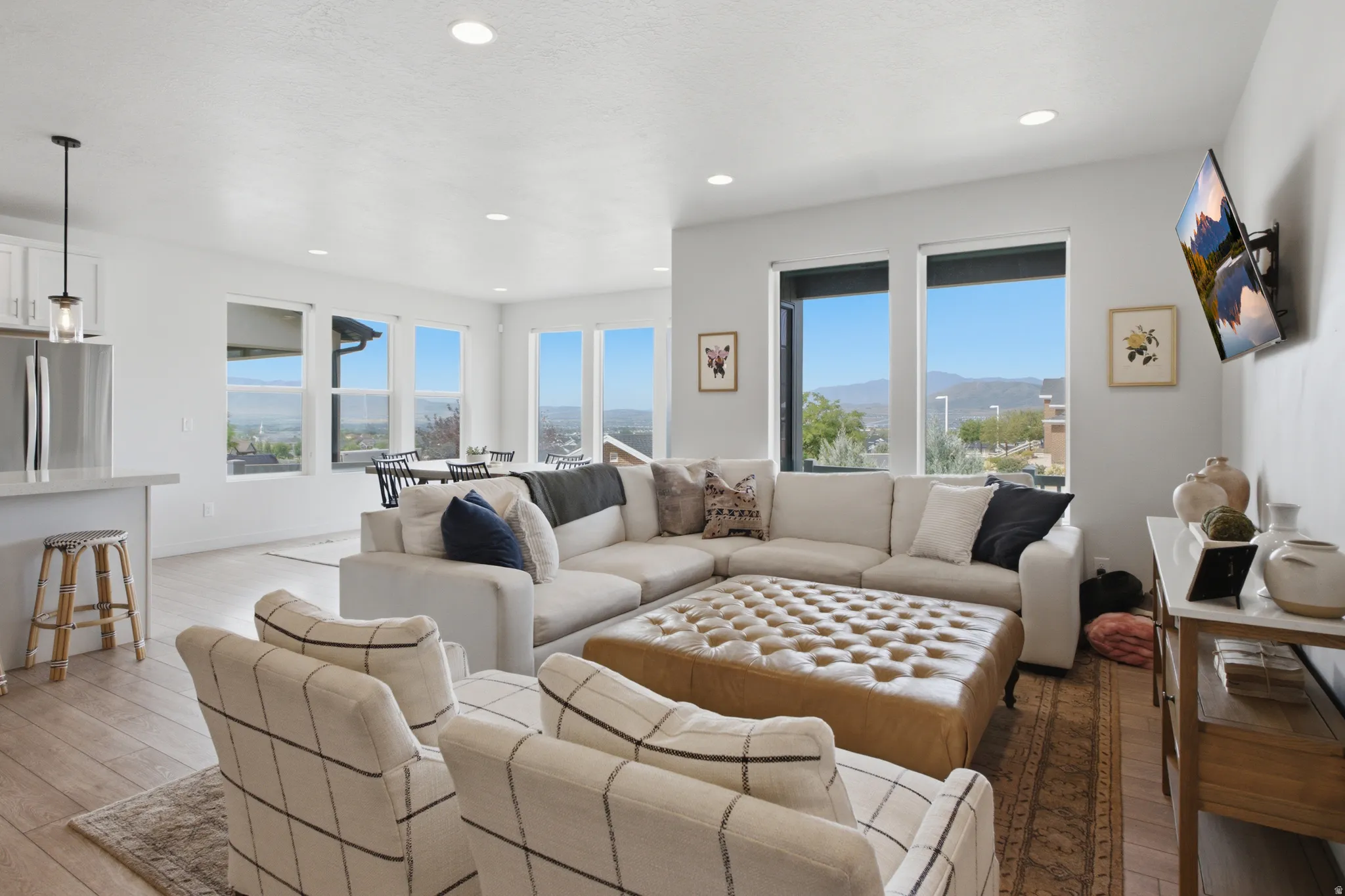 Open-concept living area with extensive window placement, recessed lighting, and wood-finish flooring