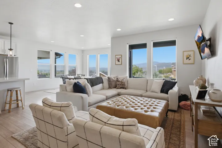 Open-concept living area with extensive window placement, recessed lighting, and wood-finish flooring