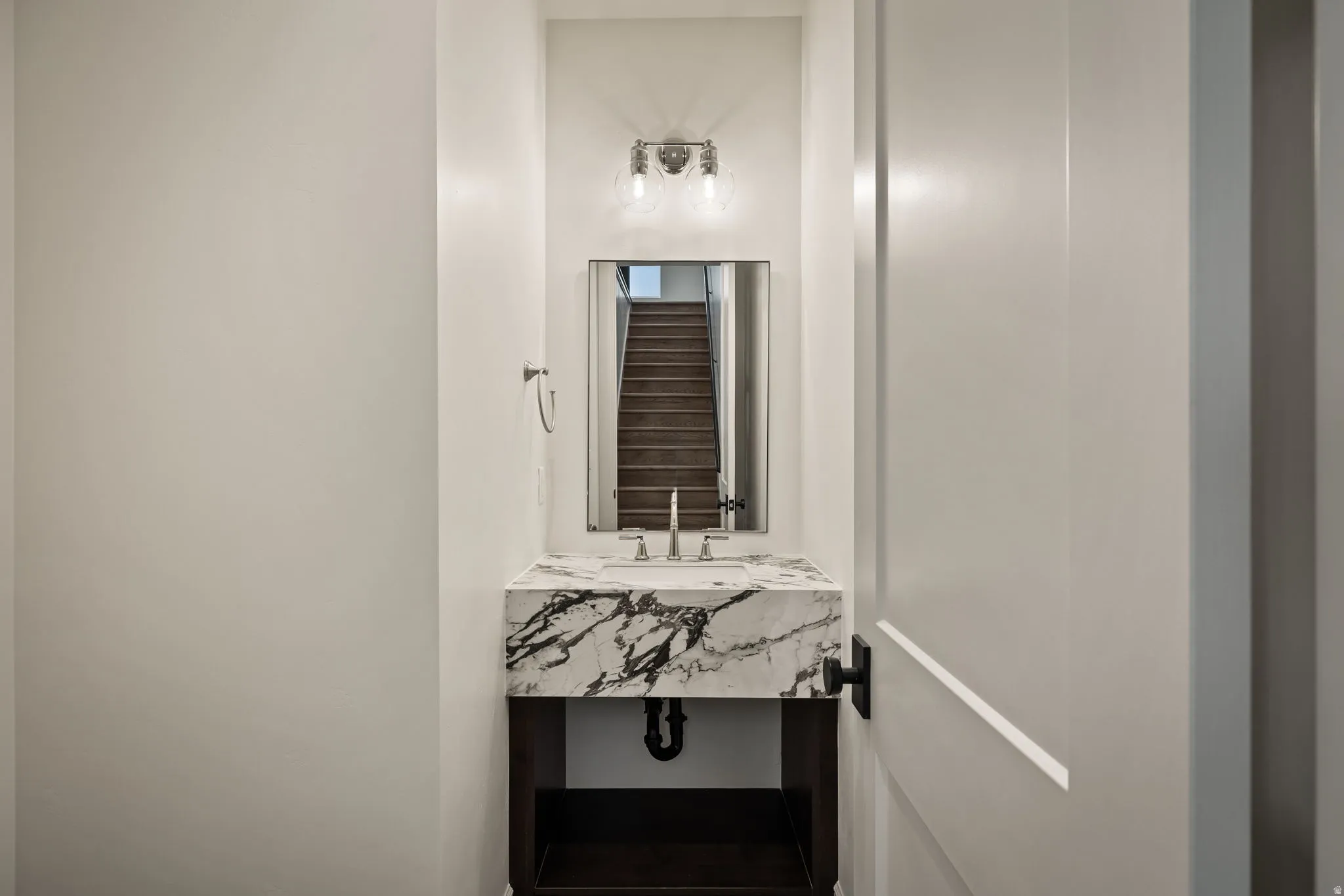 Floating vanity with a stone countertop, under-mount sink, and wall-mounted faucet