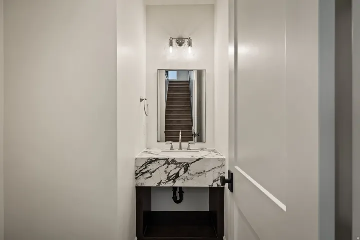 Floating vanity with a stone countertop, under-mount sink, and wall-mounted faucet