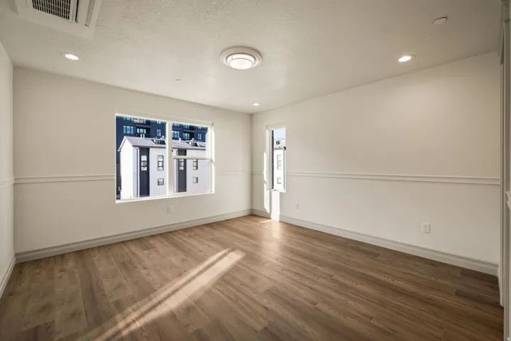 Wood-finish flooring, recessed lighting, chair rail molding, and a built-in ceiling light fixture