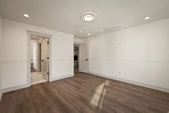 Wood-finish flooring, recessed lighting, chair rail molding, and a flush-mount ceiling fixture