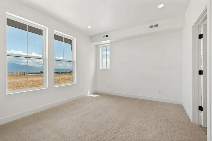Recessed lighting, light-toned carpet flooring, white painted walls, and white window trim