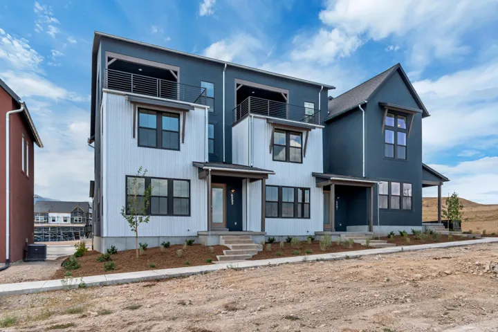 Modern multi-level townhome featuring a dark gray and white exterior with contrasting trim