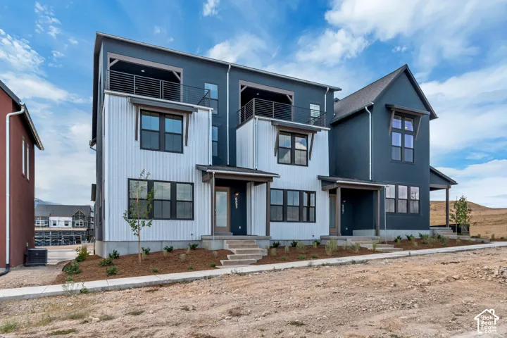 Modern multi-level townhome featuring a dark gray and white exterior with contrasting trim