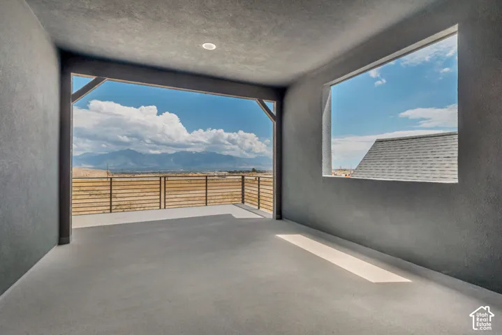 Expansive covered patio featuring a concrete floor, recessed lighting, and metal horizontal slat railing