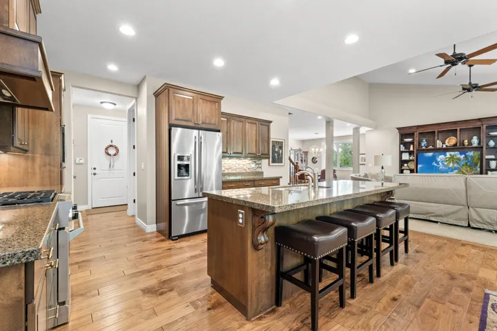 Well-appointed kitchen featuring wood cabinetry, stainless steel appliances, and a central island with a granite countertop