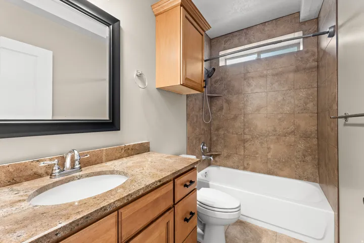 Bathroom featuring a single vanity, undermount sink, and light-toned countertop