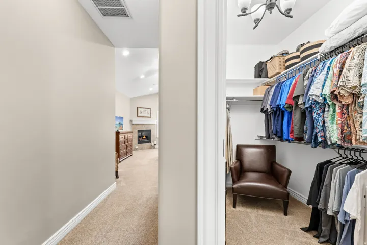 Walk-in closet with built-in shelving, hanging rods, and carpet flooring