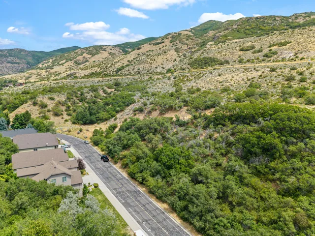 Scenic hillside property featuring a modern residence with clean architectural lines, positioned along a well-maintained access road