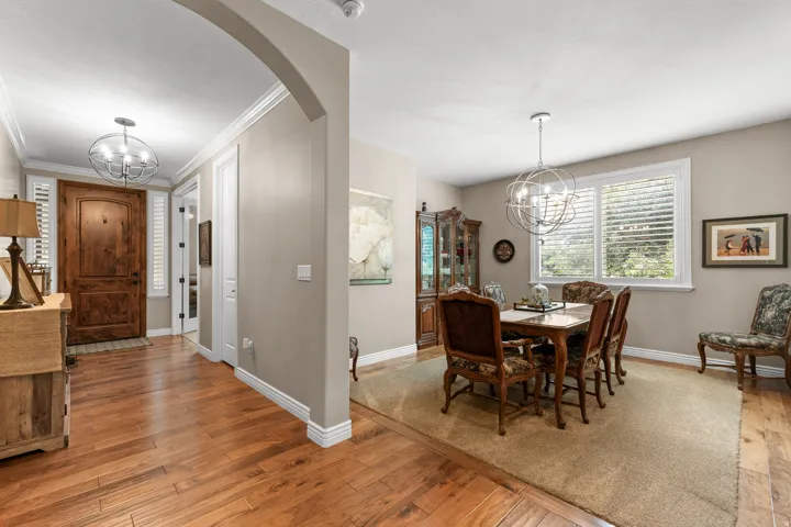 Hardwood flooring, arched entryway, wooden front door, recessed lighting, and a chandelier lighting fixture