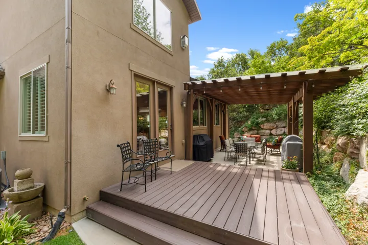 Spacious outdoor deck with a pergola, leading to a patio area