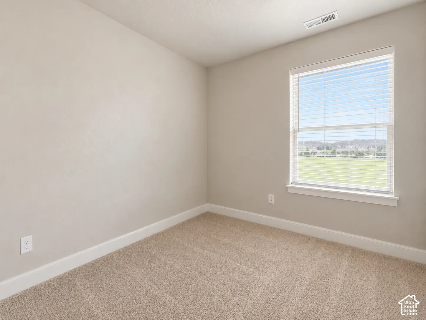 Bedroom 3. Neutral tone wall finish with light-colored carpeting, white trim, and a window featuring horizontal blinds