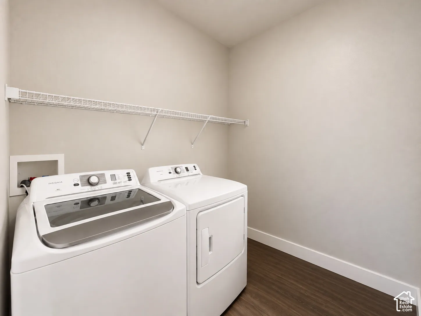 Laundry area with wood-finish flooring and a wire shelving unit
