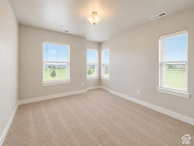 Primary room featuring pop out nook. Multiple windows, neutral wall tones, textured carpeting, recessed lighting, and a ceiling-mounted light fixture