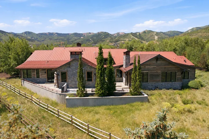 Stone and wood-clad exterior with a red metal roof