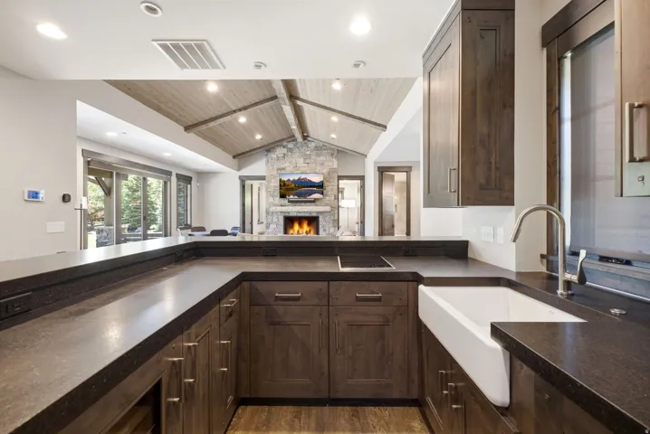 Kitchen with a farmhouse sink, dark wood cabinetry, and extensive countertop space