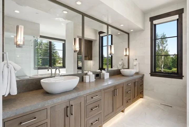 Double vanity featuring vessel sinks, extensive cabinetry, and integrated lighting