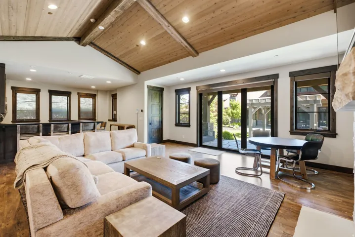 Vaulted wood-paneled ceiling with exposed beams, recessed lighting, and wood-finish flooring