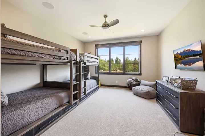 Recessed lighting, ceiling fan, carpeted flooring, large window with dark trim, and built-in bunk beds with storage drawers