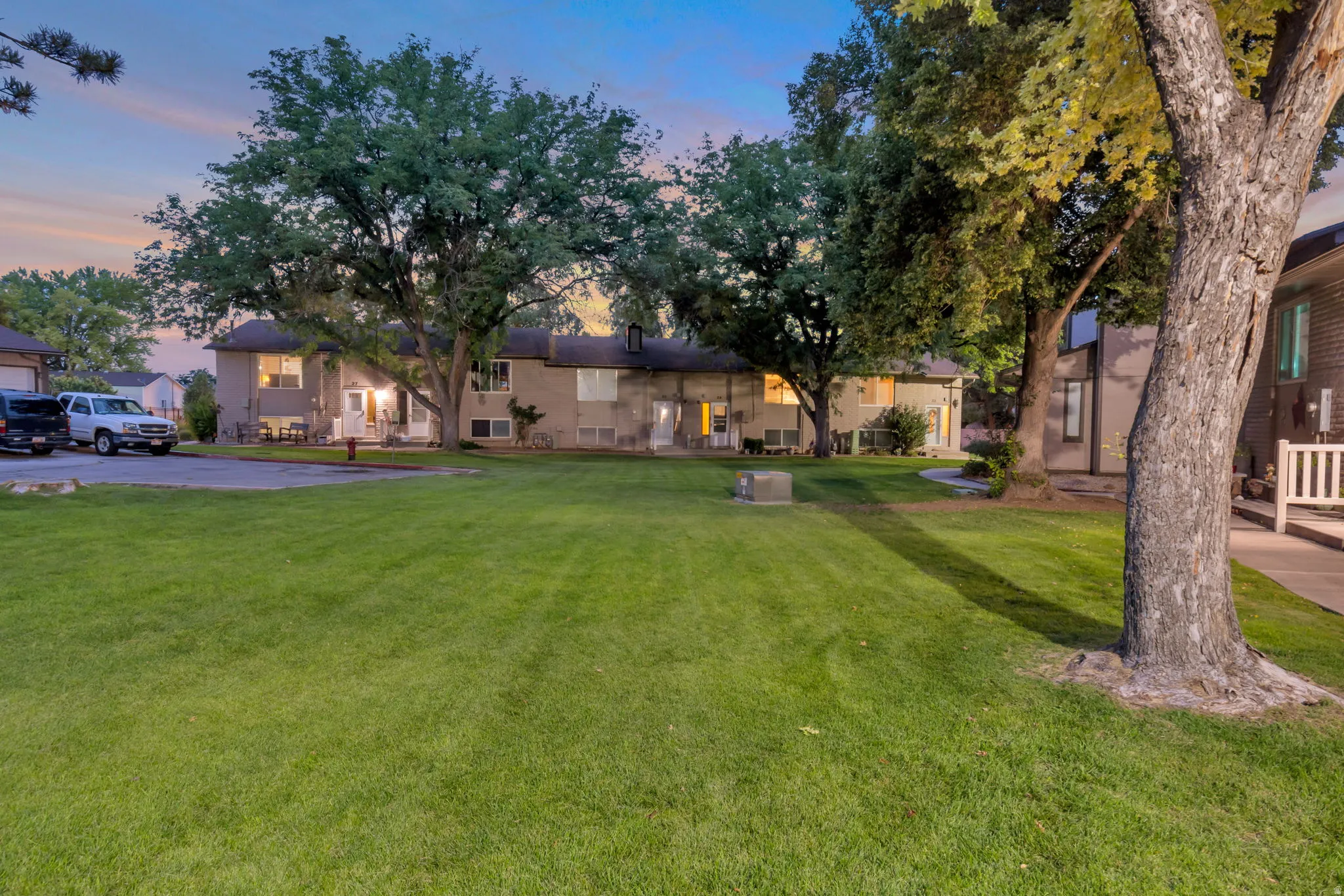 Expansive grassy area with mature trees and paved pathways