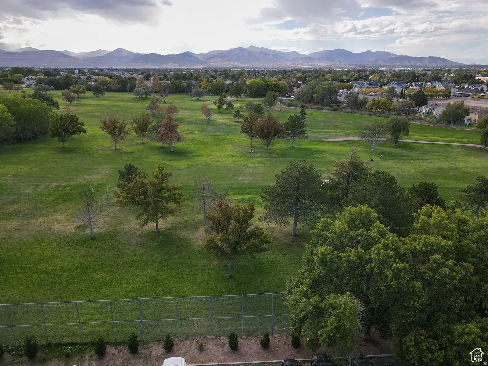 Expansive green space featuring mature trees and a distant mountain range